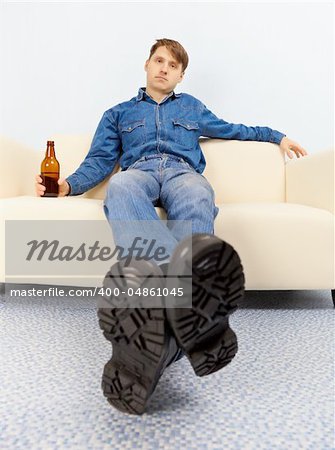 Drunk dude sprawled comfortably on the couch with beer