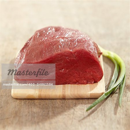 fresh raw meat on wooden cutting board