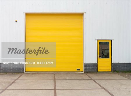 small industrial warehouse with a single yellow roller door
