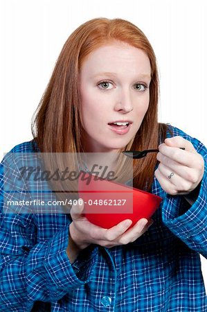 A beautiful woman eating food from a bowl