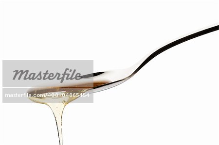 honey falls from a spoon on white background