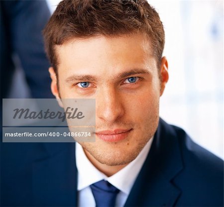 Closeup portrait of smiling young businessman working at the office.