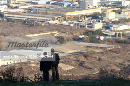 Silhouettes of two boys overlooking industrial zone