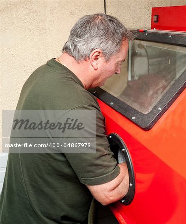 Operator working at a sandblasting machine