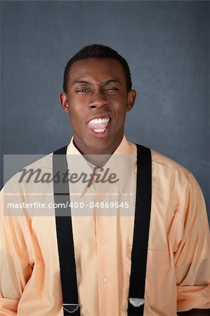 Young African-American male in suspenders makes funny faces