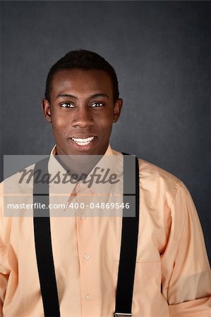 Cute young African-American adult with suspenders smiles