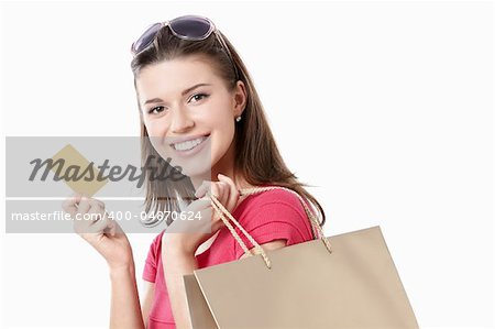 Young girl with a credit card and shopping bags isolated