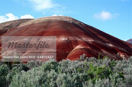 A deep red hill with white stripes in the Painted Hills of Central Oregon