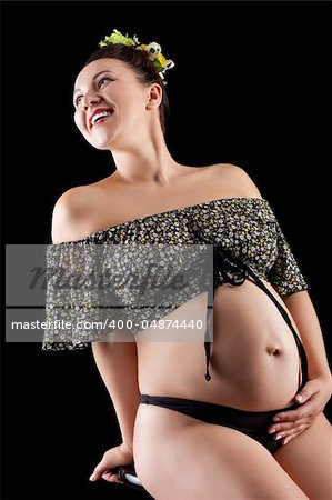 Beautiful young pregnant woman, isolated on black