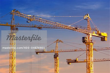 tall cranes on blue sky background