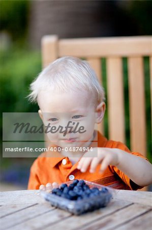 adorable toddler eating blueberries