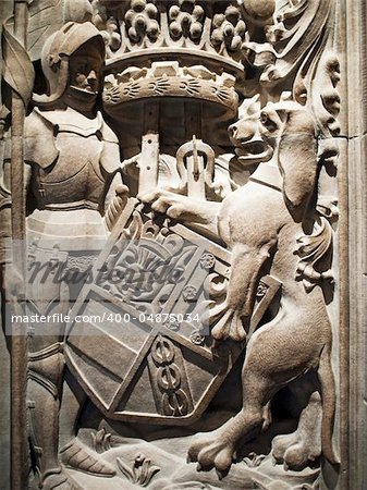 A knight and lion holding a family crest as observed on the entrance column to the Thistle Chapel in St. Giles Cathedral in Edinburgh, Scotland.