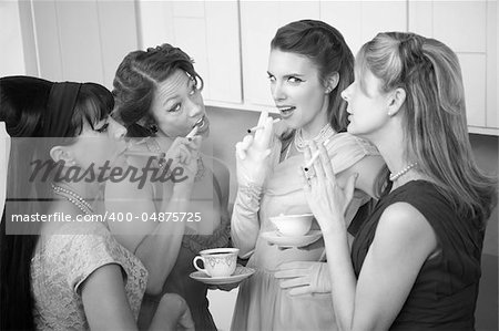 Four retro-styled women smoking cigarettes and drinking coffee in a kitchen