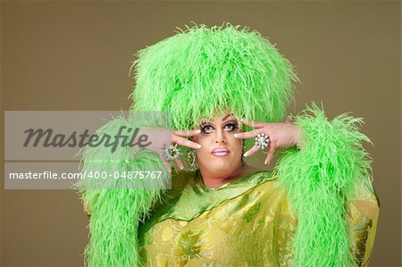 Flamboyant drag queen in boa hat on green background
