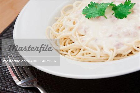 Spaghetti carbonara with bacon, cream and cheese sauce served on a white plate