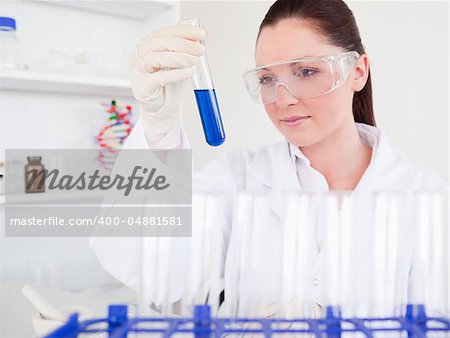 Beautiful red-haired woman holding a test tube in a lab