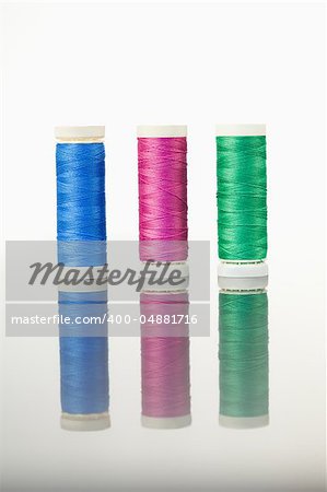 Colorful spools of thread on a table against a white background