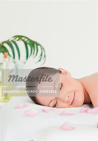 Portrait of a young woman lying on a massage table with petals