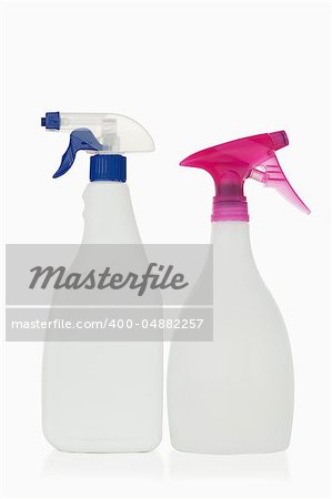 Pink and blue spray bottles against a white background