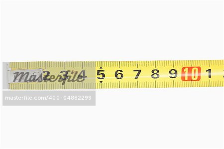 Close up of a yellow measuring tape against a white background