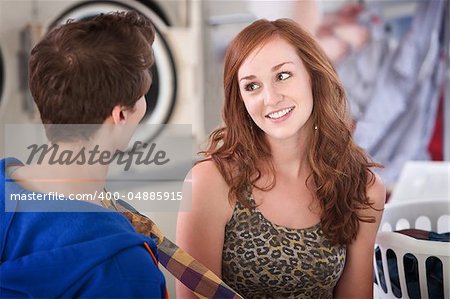 Smiling Woman flirts with man in laundromat