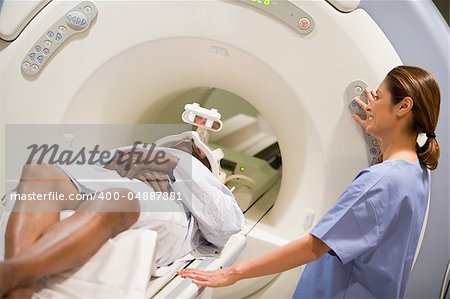 Nurse With Patient As They Prepare For A Computerized Axial Tomography (CAT) Scan