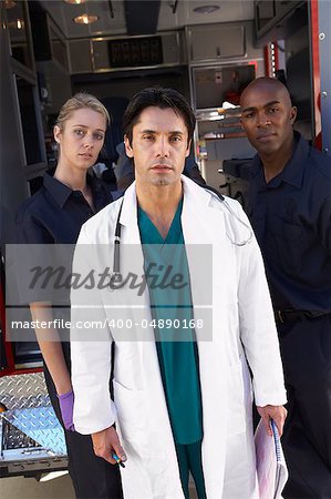 Portrait of doctor with two paramedics in front of ambulance