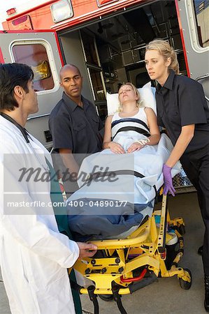 Paramedics and doctor unloading patient from ambulance