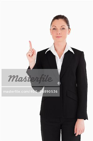 Attractive woman in suit pointing at a copy space while standing against a white background