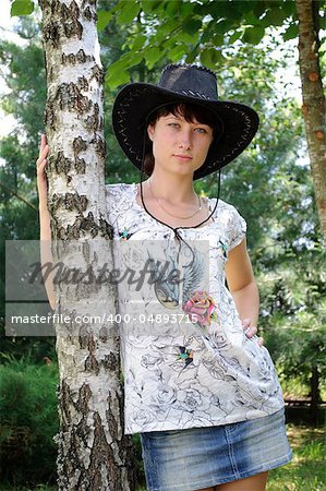 beautiful girl in the hat around birch