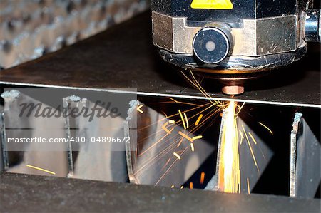 Close-up photo of the industrial laser with sparks flying around (with copy space)