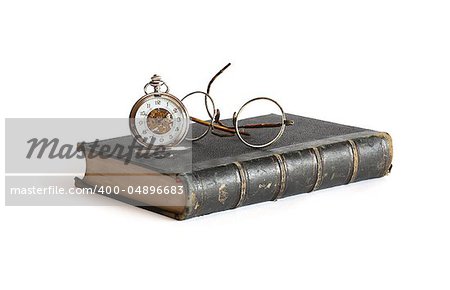 Vintage pocket watch near spectacles on old book