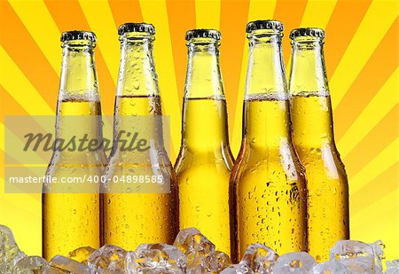 Bottles of beer in ice with abstract orange background