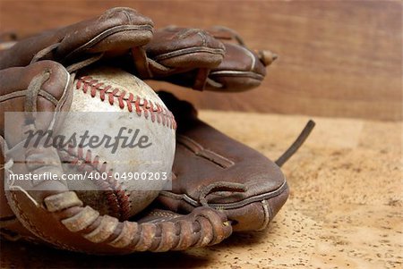 A low contrast image of a well used hardball and glove for those who love the sport of baseball.