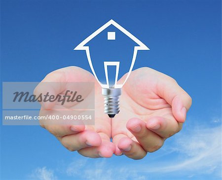 light bulb model of a house in women hand on sky