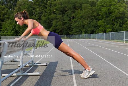 An athletic teenager stretching before exercising on a track outdoors