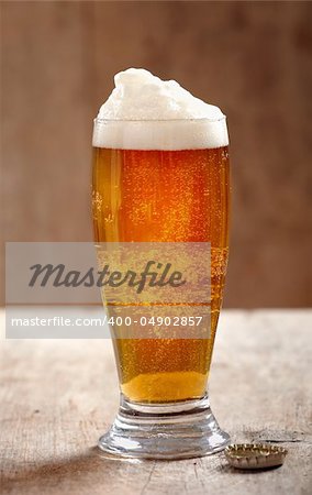 glass of fresh beer on old wooden table