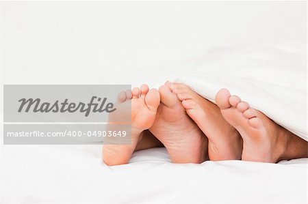 Four feet in a bed against a white background