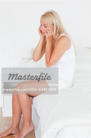 Portrait of a woman having a headache in her bedroom