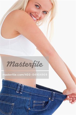 Lady wearing to big jeans in a studio