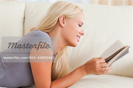 Cute woman reading a book in her living room