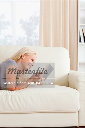 Portrait of a cute woman reading a book in her living room