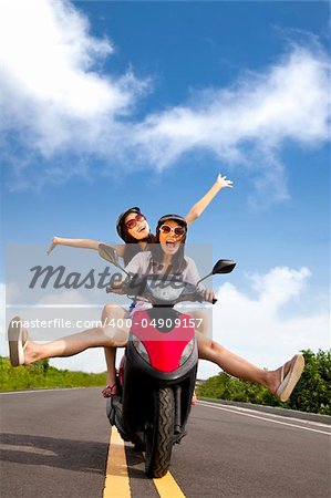 Happy young woman having summer trip on a scooter