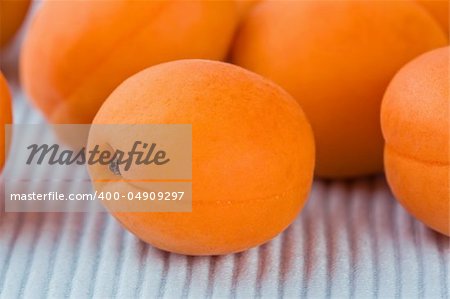 Ripe fresh apricot on blue background close-up shallow DOF