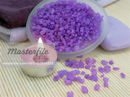 Bath salt, aroma candle, soap and towels on bamboo mat