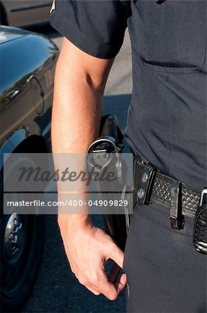 a police officer standing, showing off his duty gear,