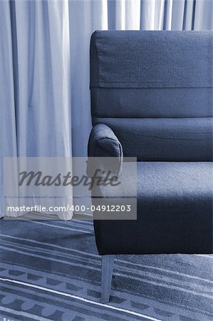 old single sofa seat in front of a curtain