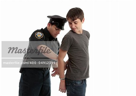 A police officer arrests and handcuffs a young male teen felon.