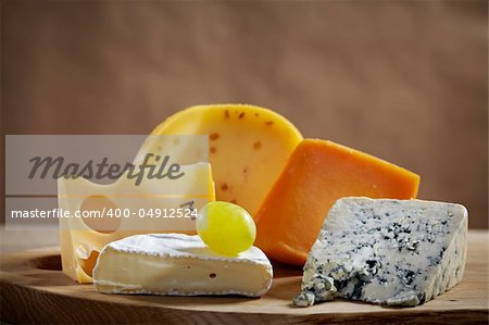 various types of cheese on wooden cutting board