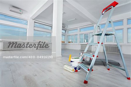 Newly renovated generic empty office space with leftover materials and ladder in foreground